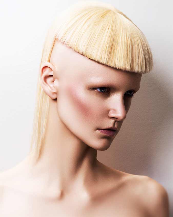 capelli rasati ai lati con frangia biondi. Blonde hair, shaved on the sides with bangs.