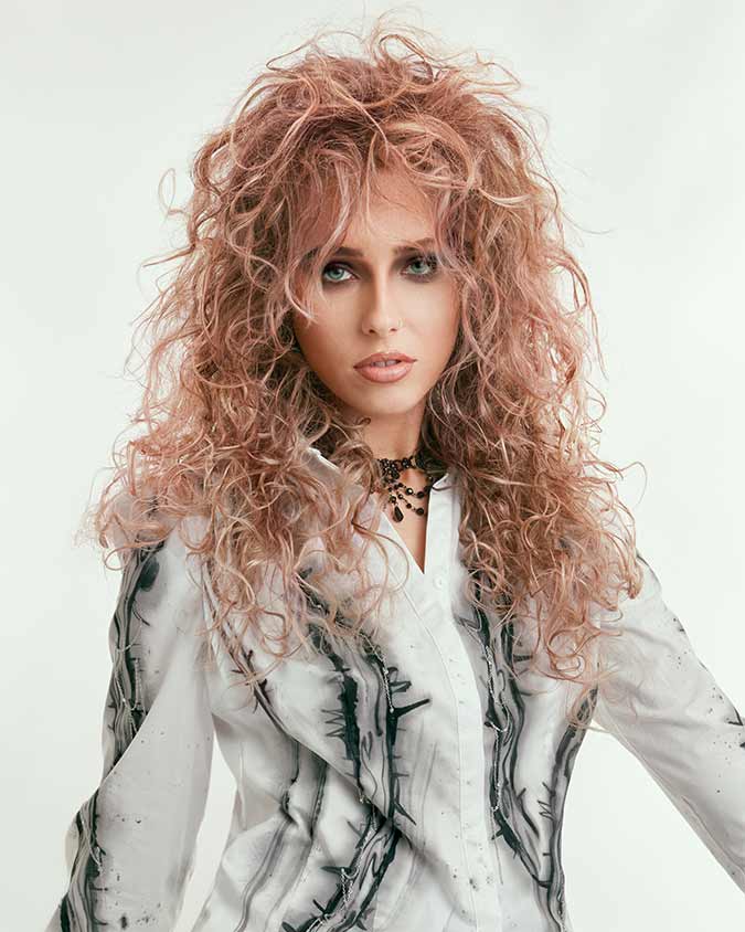 capelli lunghi, biondi, ricci. Long, blonde, curly hair.